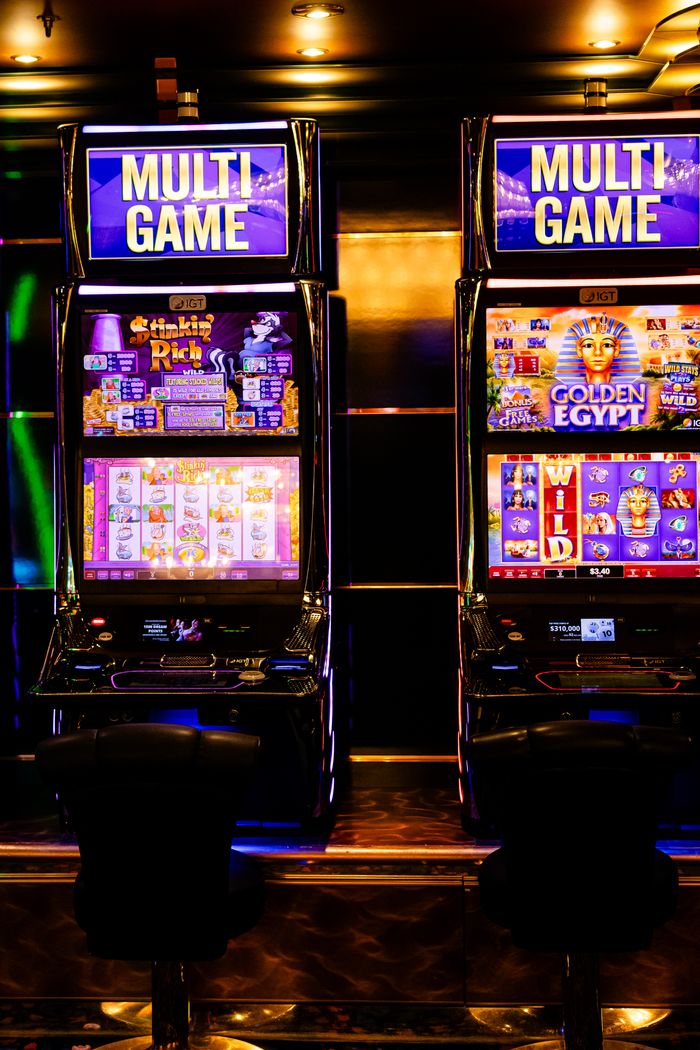 about-us-01 Colorful multi-game slot machines inside a lively casino environment at night.